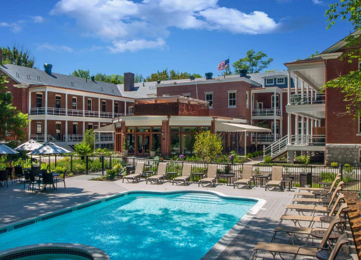 a pool at a hotel with chairs and a building at Inn at Diamond Cove in Portland