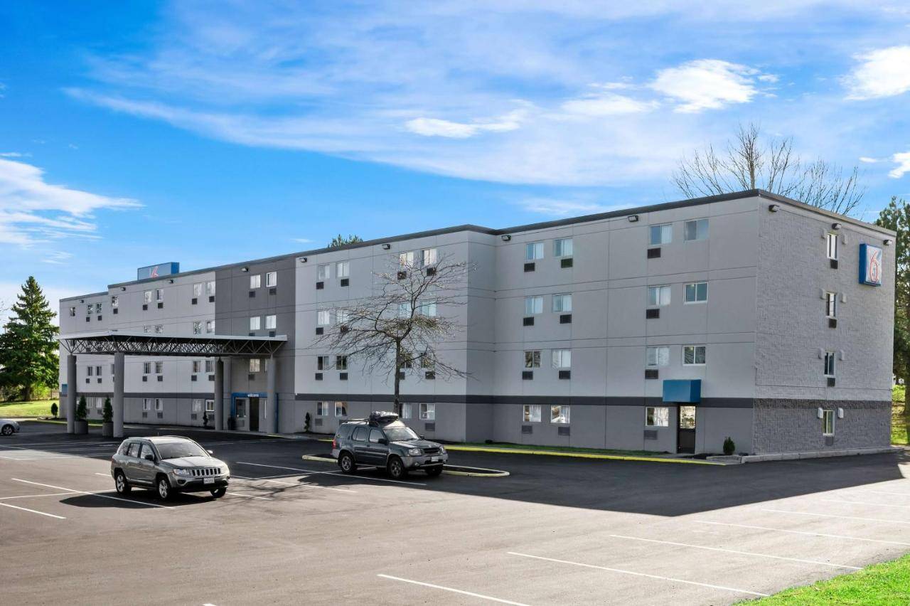 a large building with two cars parked in a parking lot at Motel 6-Portland, ME in Portland