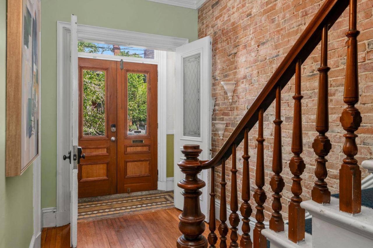 a staircase with a brick wall and a wooden door at Stylish Downtown Condo in a Historic Landmark Home in Portland
