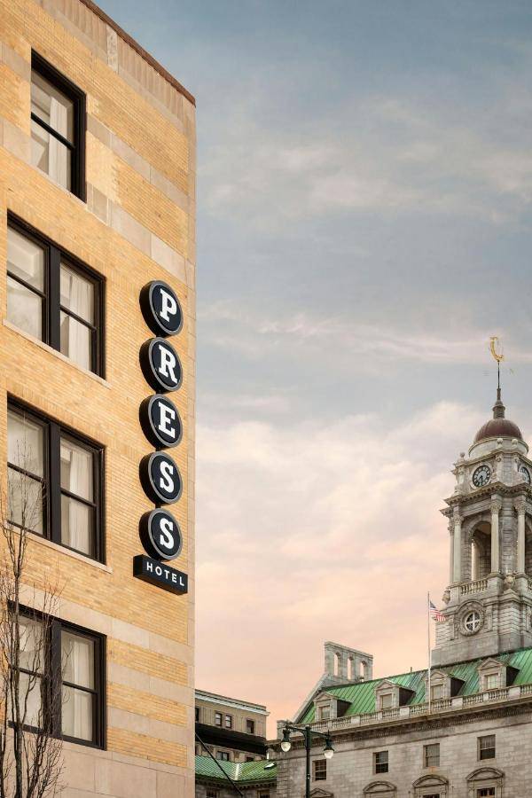 a sign on the side of a building with a clock tower at The Press Hotel, Autograph Collection in Portland