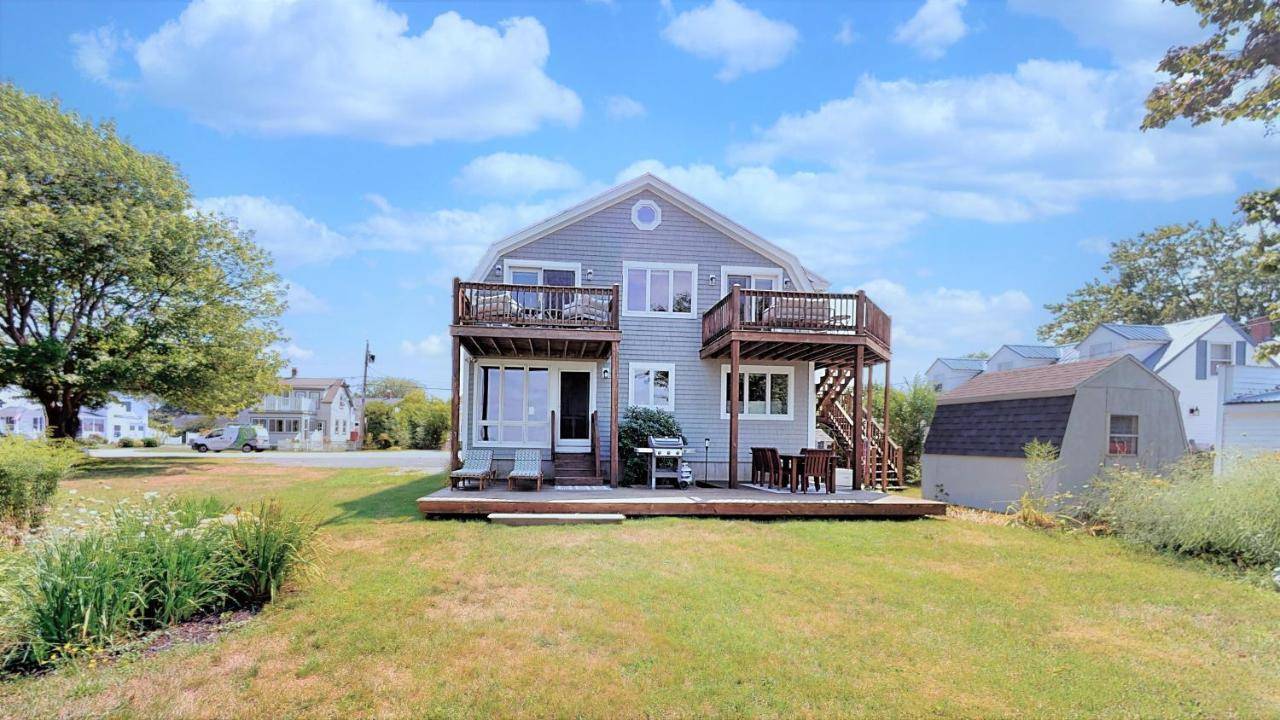 a house with a deck on a lawn at A Wave from it All by Bayley Vacation Rentals in Scarborough