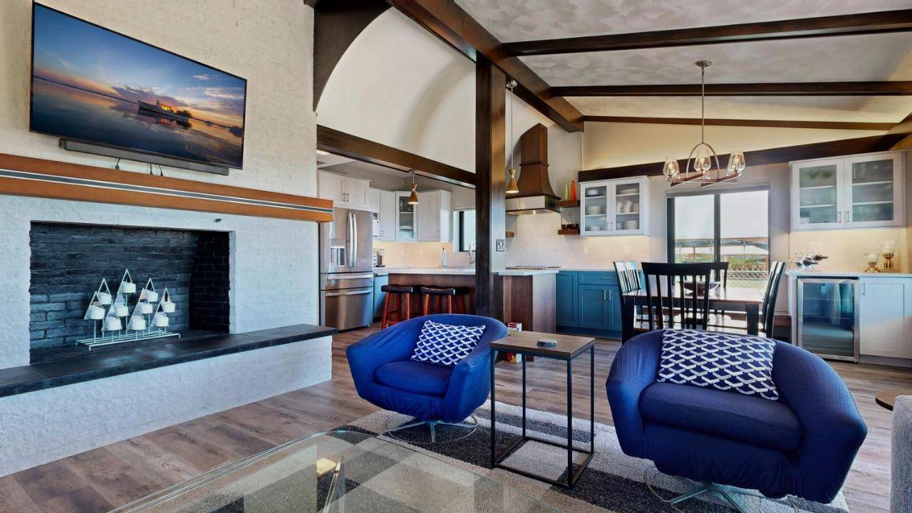 a living room with a fireplace and a kitchen at Coastal Escape by Bayley Vacation Rentals in Scarborough