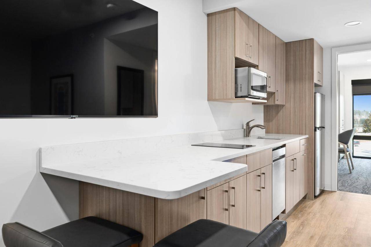 a kitchen with a white counter top and wooden cabinets at HomeAwhile in Scarborough