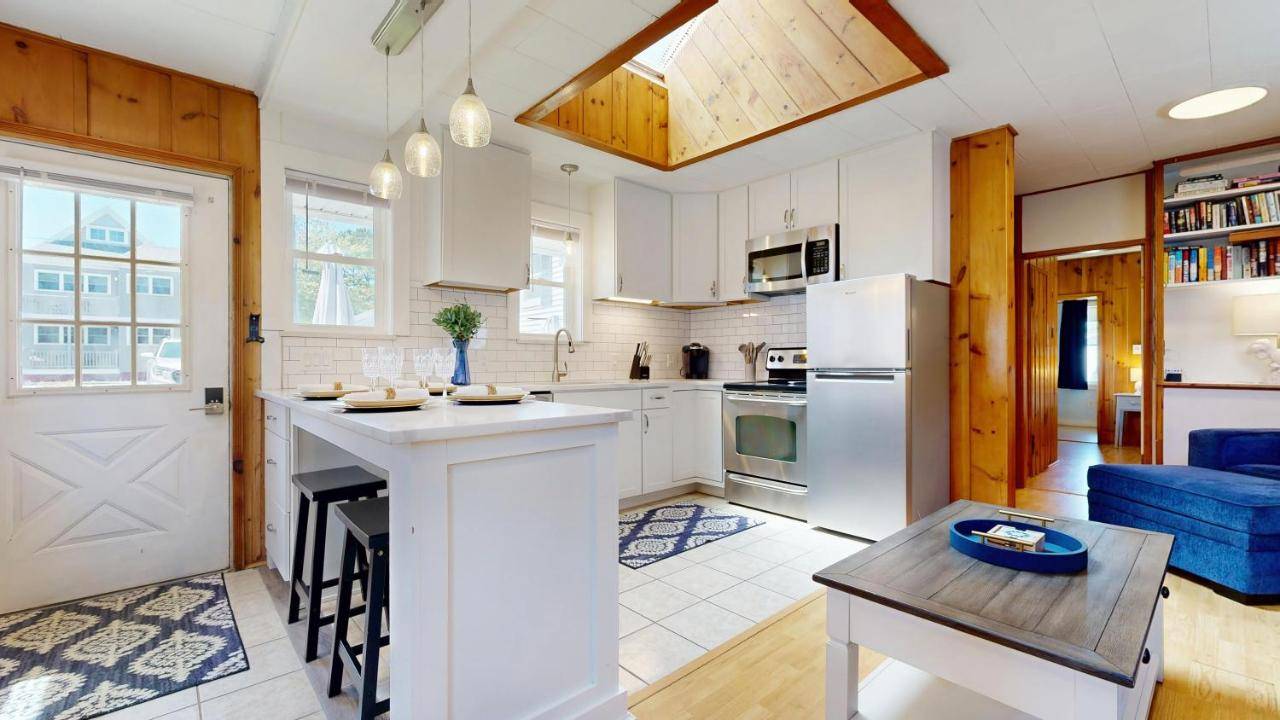 a kitchen with white appliances and a table in it at Niblet Cottage by Bayley Vacation Rentals in Scarborough