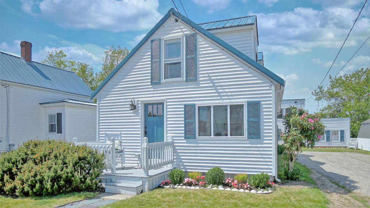 a white house with a bench in front of it at The Cove by Bayley Vacation Rentals in Scarborough
