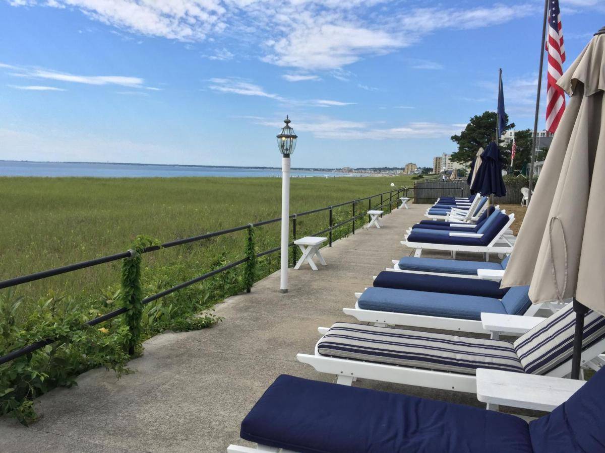 a row of lounge chairs and umbrellas on the beach at The Holiday House Inn & Motel in Scarborough