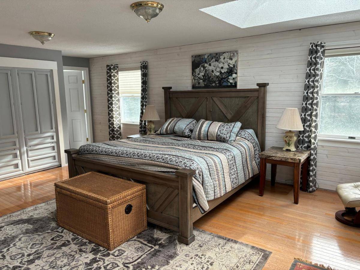 a bedroom with a large bed with a wooden headboard at Christmas Cove Inn in South Bristol