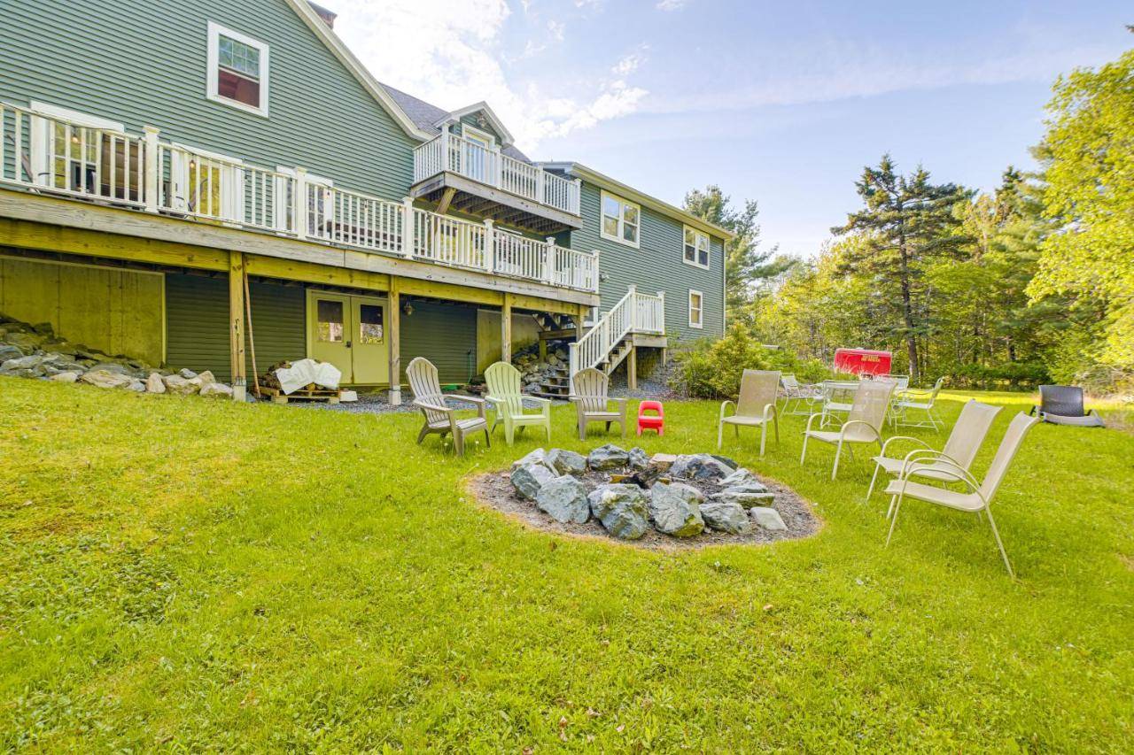 a yard with chairs and a fire pit in front of a house at 1 Mi to Acadia National Park Spacious Retreat! in Southwest Harbor