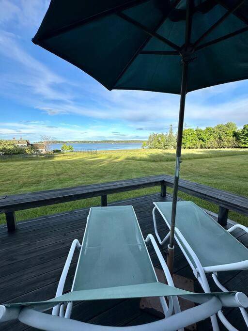 a couple of chairs and an umbrella on a deck at Hard Aground - Ocean View - Pet Friendly! SWH in Southwest Harbor