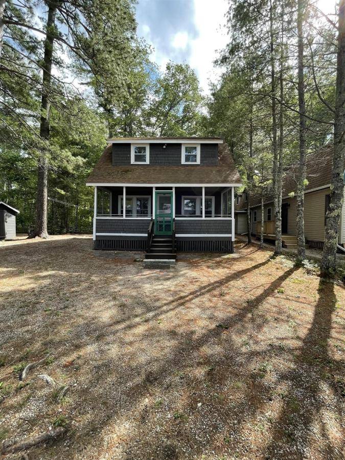 a house with a large yard in the woods at FLETCHER LIMIT 8 cottage in Standish