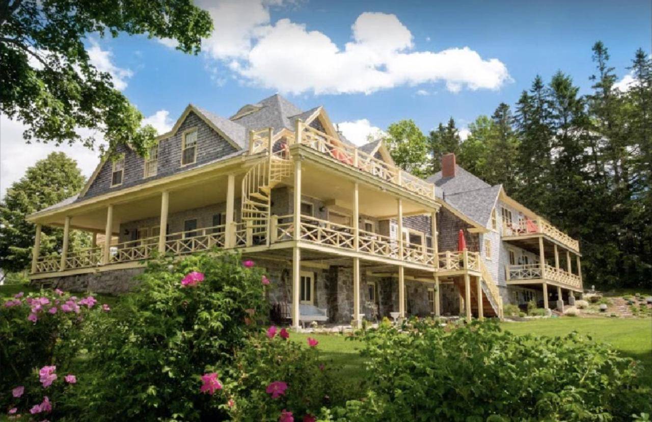 a large house with a wrap around porch at Acadia Bay Inn in Sullivan