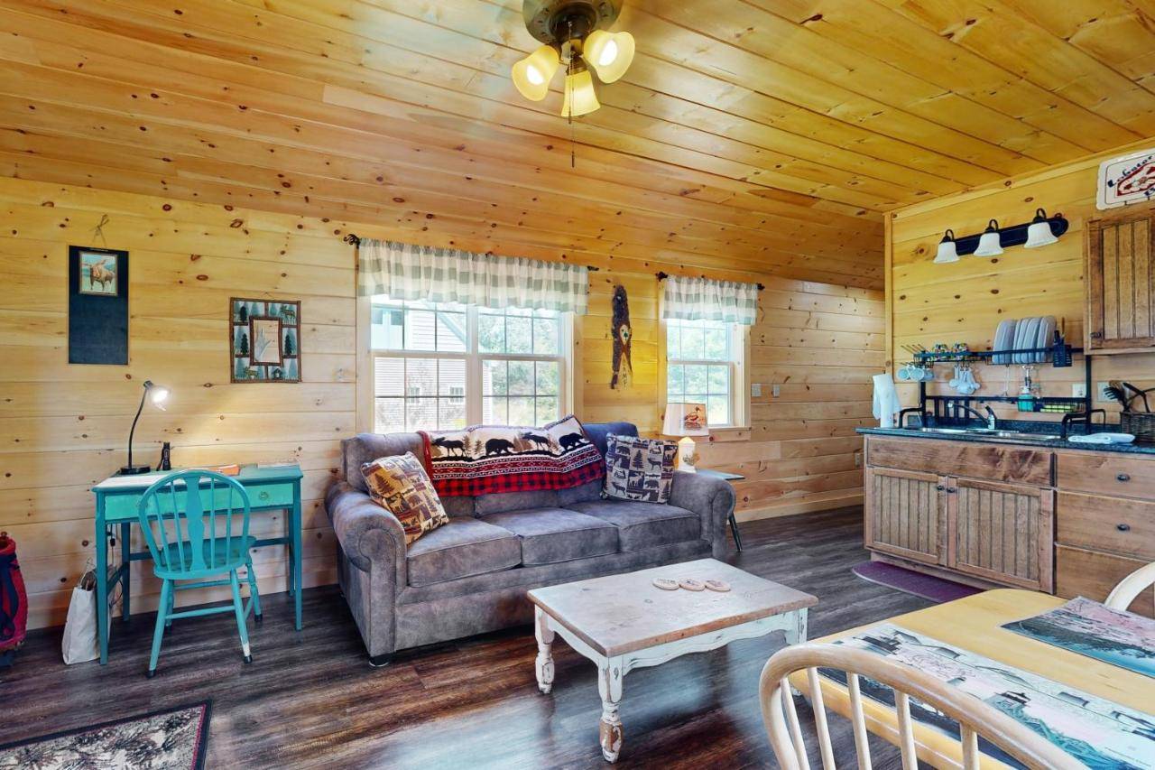 a living room with a couch and a table at Acadia Lights Cabin in Sullivan