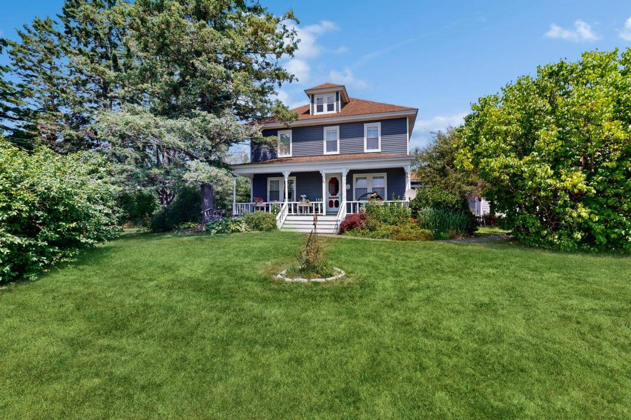 a house with a large yard with green grass at Acadia Lights Cottage & Cabin in Sullivan