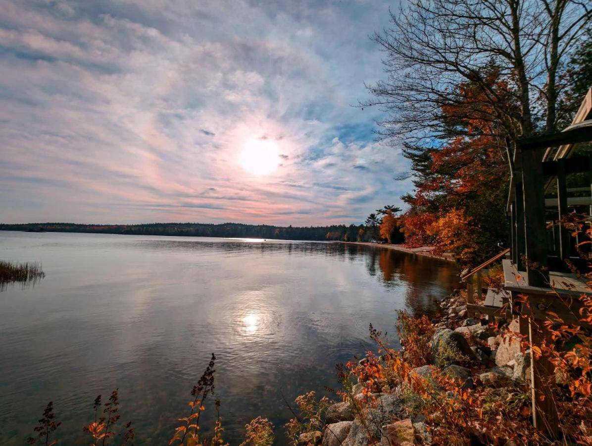 a view of a river with the sun in the sky at Back of the Moon Lakefront Camp family watersports fire pit 1 dog beach sleeps 8 in Sullivan