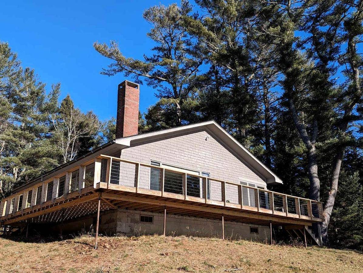 a house on top of a hill with trees at Secluded Oceanfront Cottage with Wrap-Around Deck near Acadia National Park, Sullivan, Maine in Sullivan
