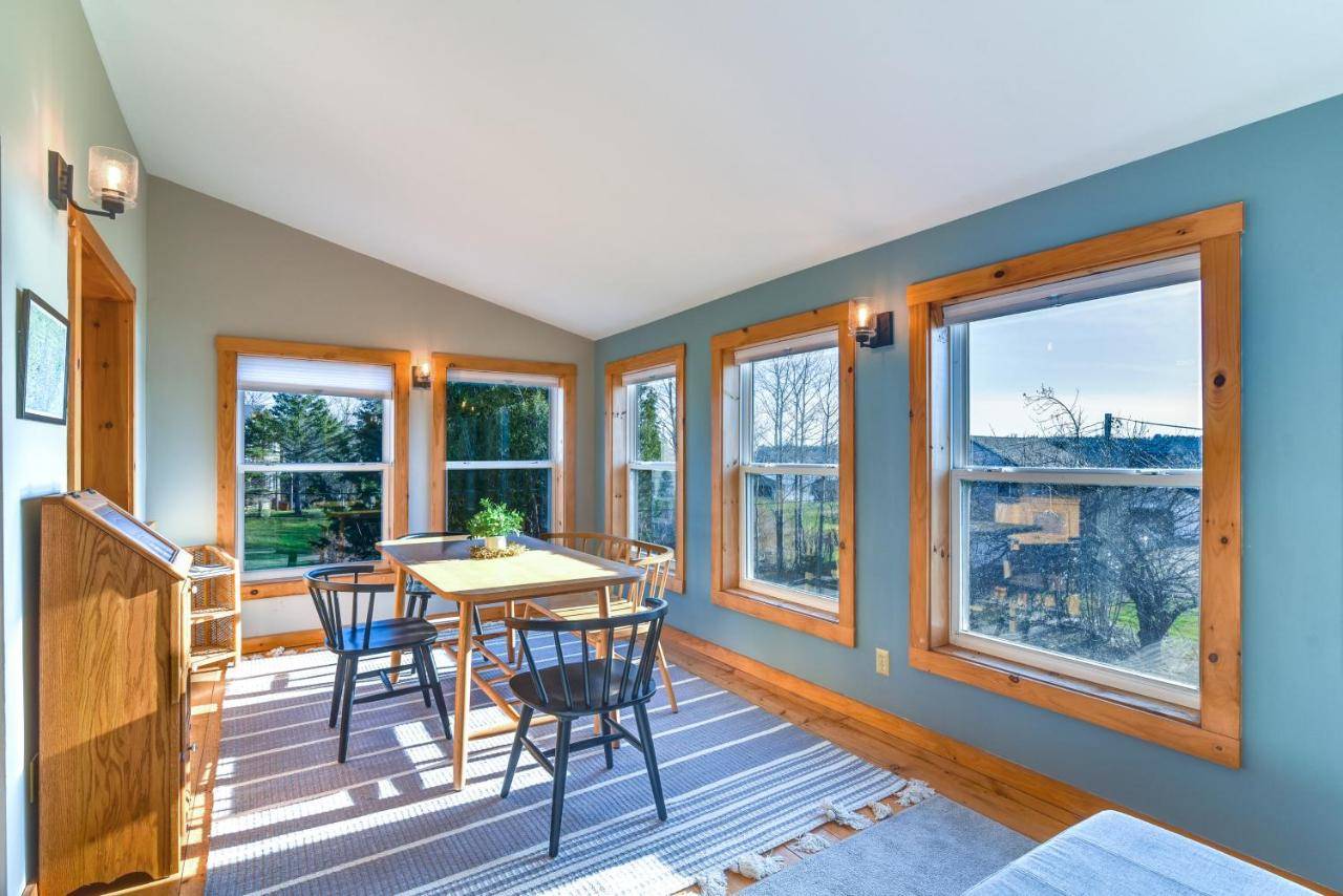 a dining room with a table and chairs and windows at Oceanside Bass Harbor Home with Peaceful Deck! in Tremont