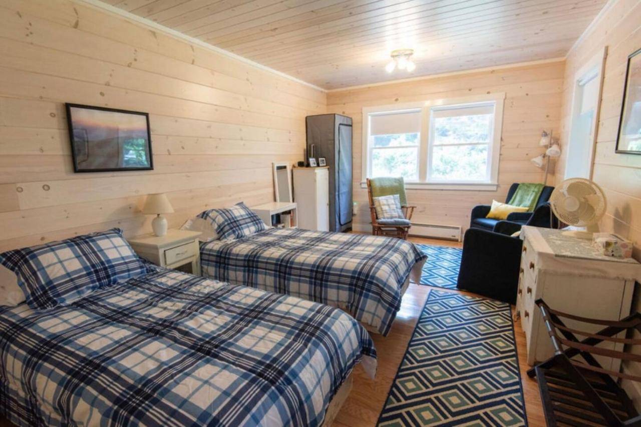 a bedroom with two beds and a refrigerator at Secluded Cabin With Ocean Access in Tremont