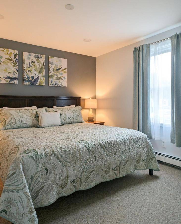 a bedroom with a large bed and a window at Woodland Apartments - Acadia National Park in Tremont