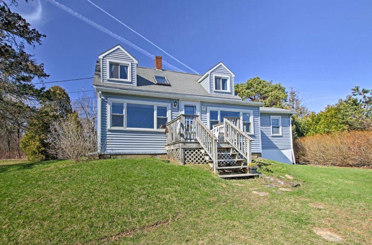 a blue house with a staircase in a yard at Waterfront Tidal Cove Cottage-Kayak and Views! in Trevett