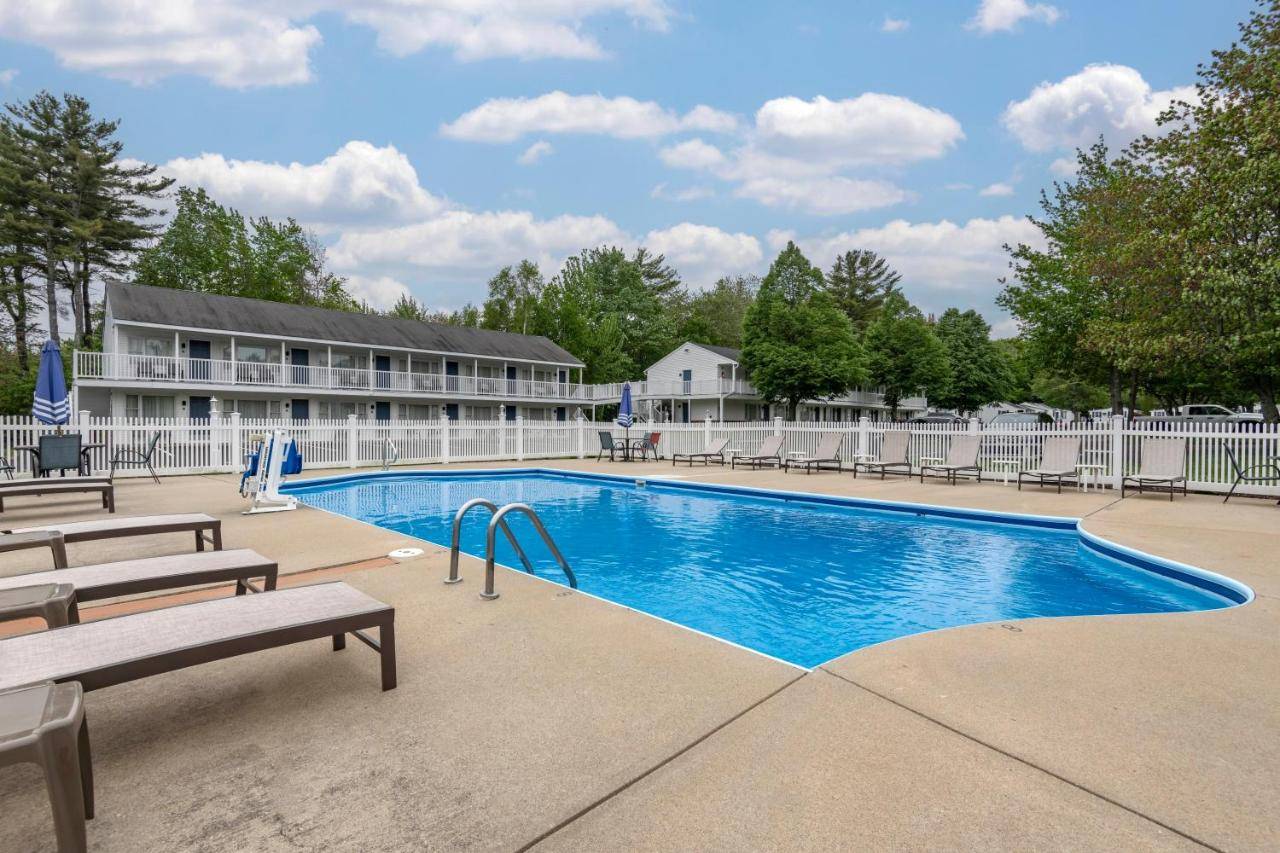 a pool at a resort with benches and a building at Anchor Inn and Cottages Wells-Ogunquit in Wells
