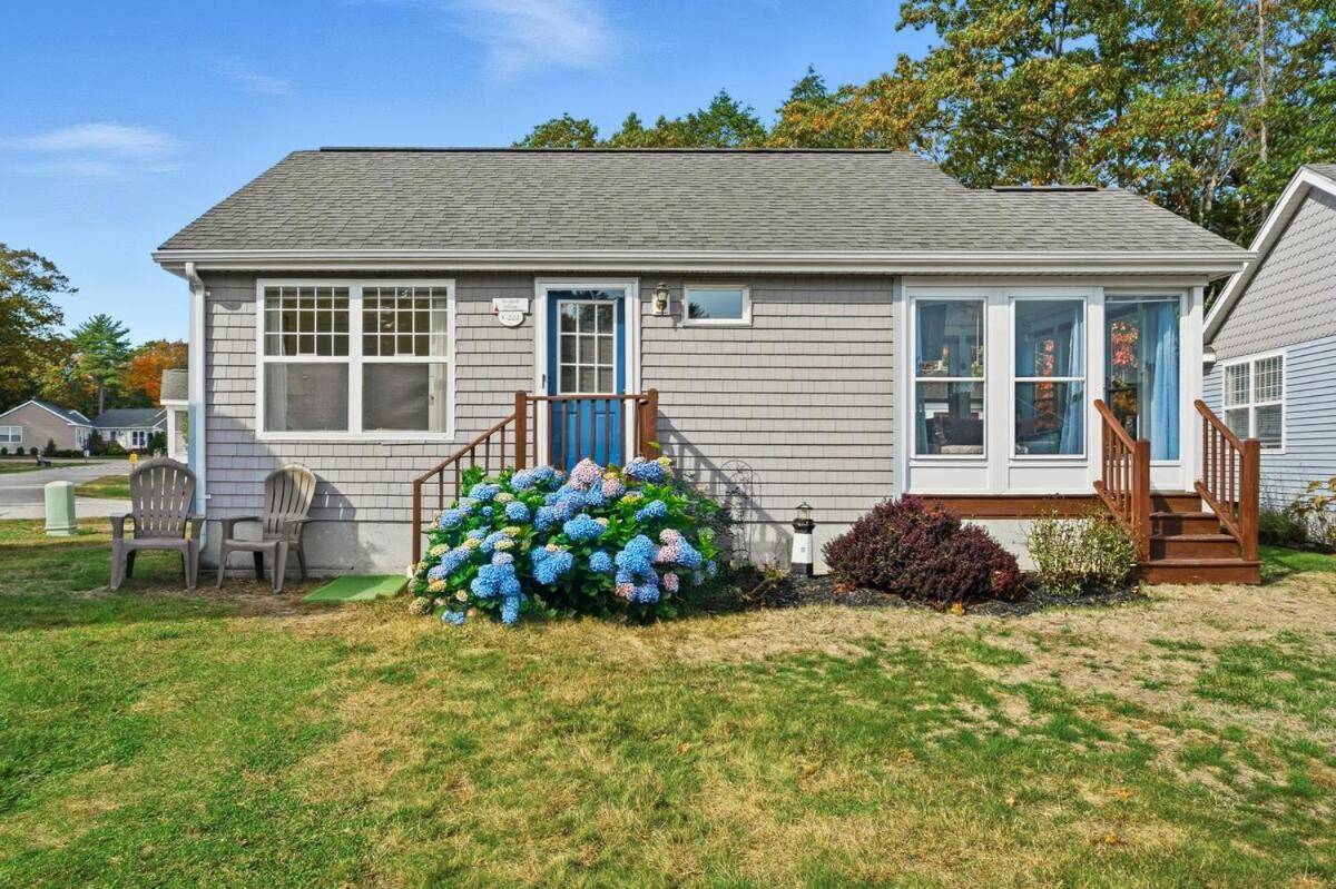a house with a bunch of flowers in front of it at Beach Gear Included! Updated 2BR Cottage and Pool in Wells