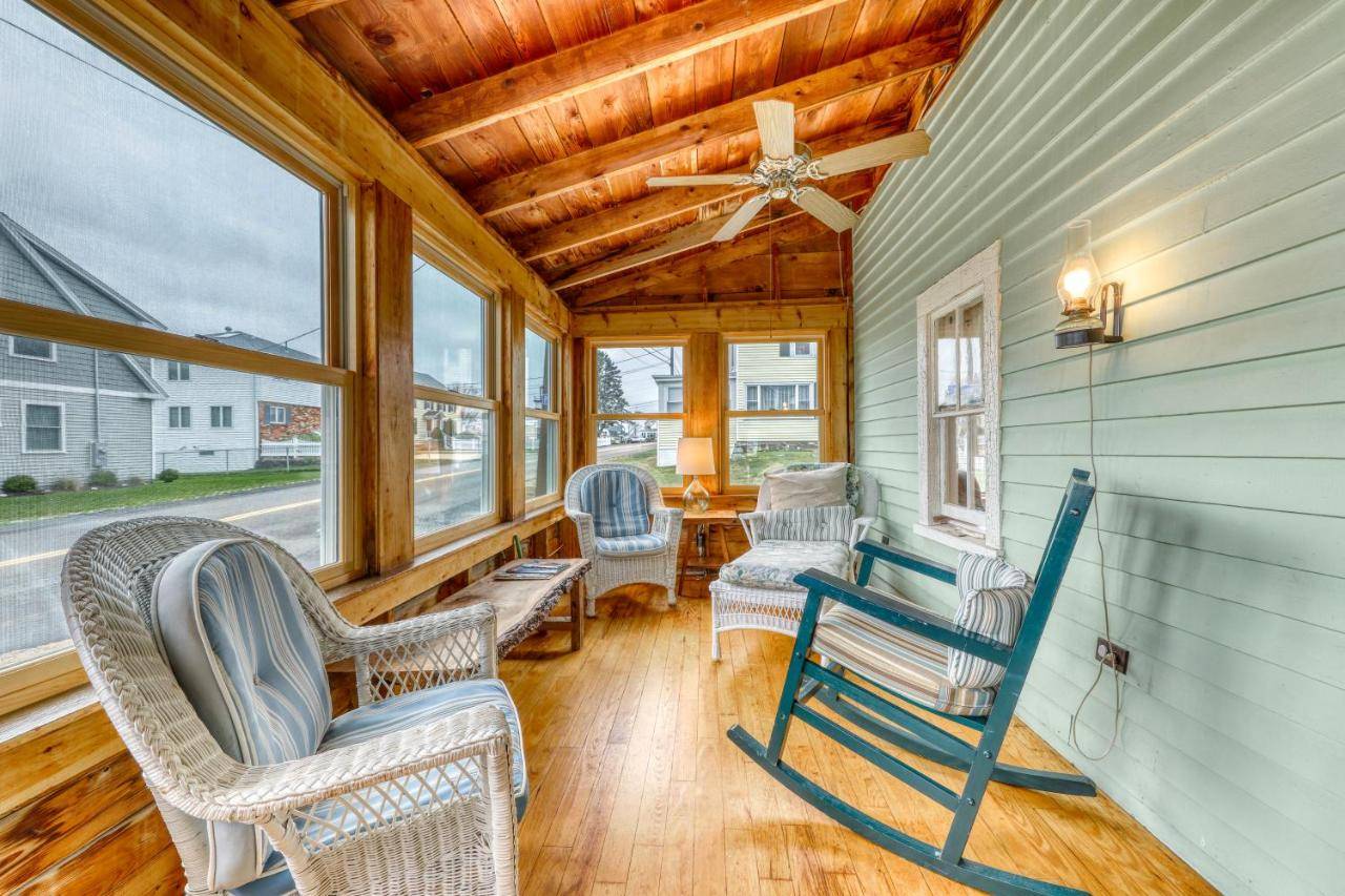 a porch with chairs and a ceiling fan and windows at Cottage on the Cove in Wells