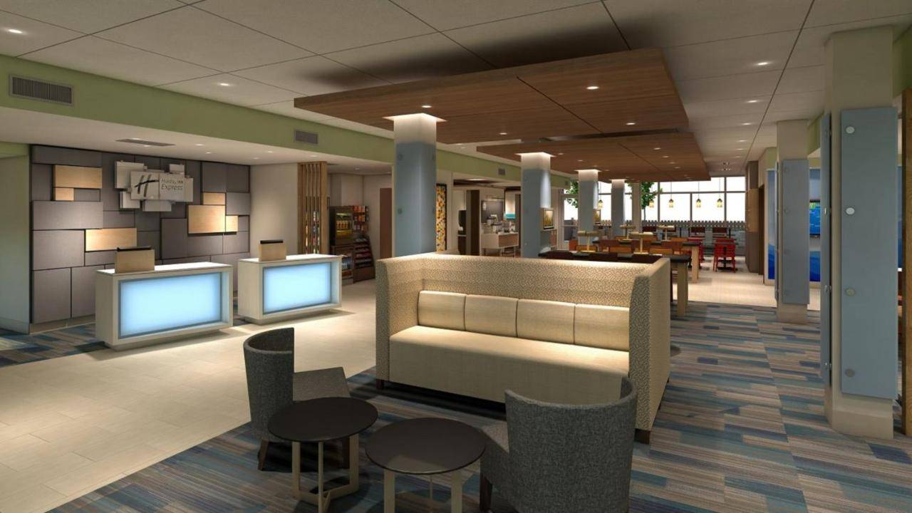 a lobby with two monitors and tables and chairs at Holiday Inn Express - Wells-Ogunquit-Kennebunk by IHG in Wells