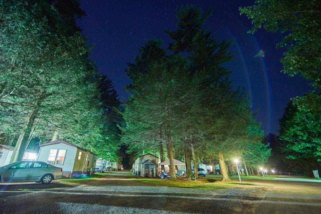 a street at night with a car parked in front of trees at Moody Beach Camping Resort Cottage - Two Bedroom Deluxe in Wells