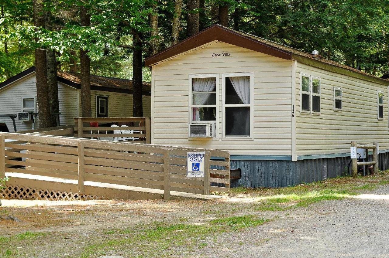 a white house with a fence in front of it at Moody Beach Camping Resort Wheelchair Accessible Cottage in Wells