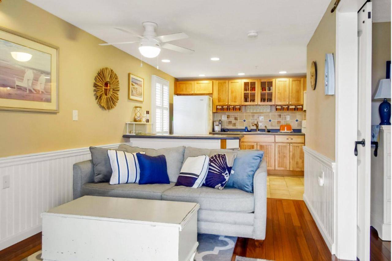 a living room with a couch and a kitchen at Sand & Surf at Wells Beach in Wells