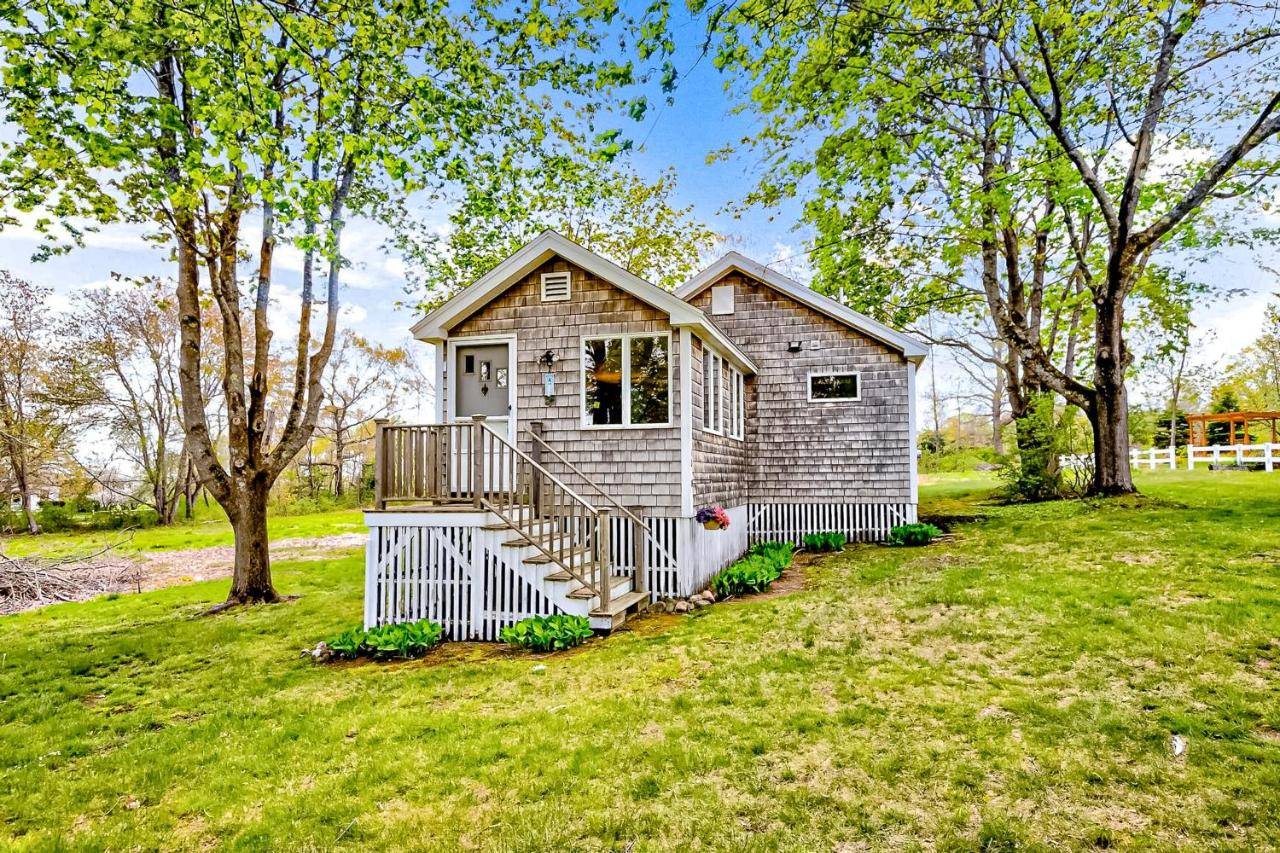 a small house in a field with trees at Seaside Cottage in Wells