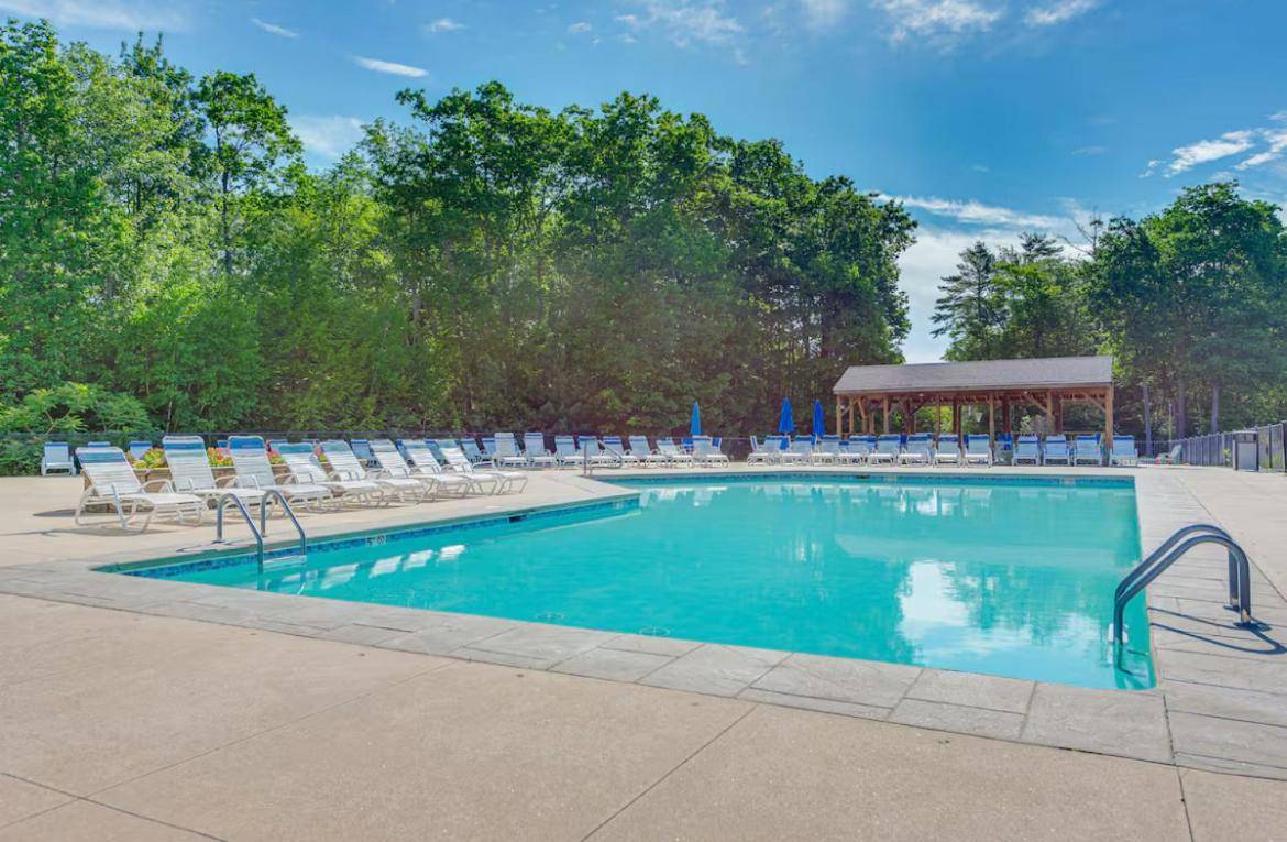 a large swimming pool with chairs and a gazebo at 2026 Summer Cottage Sleeps 6, 2 Bedrooms Sun Room Jaccuzi 1 Mile to Beach! in Wells
