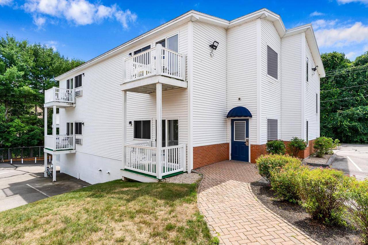 a white house with a blue door and balcony at USA Inn in Wells