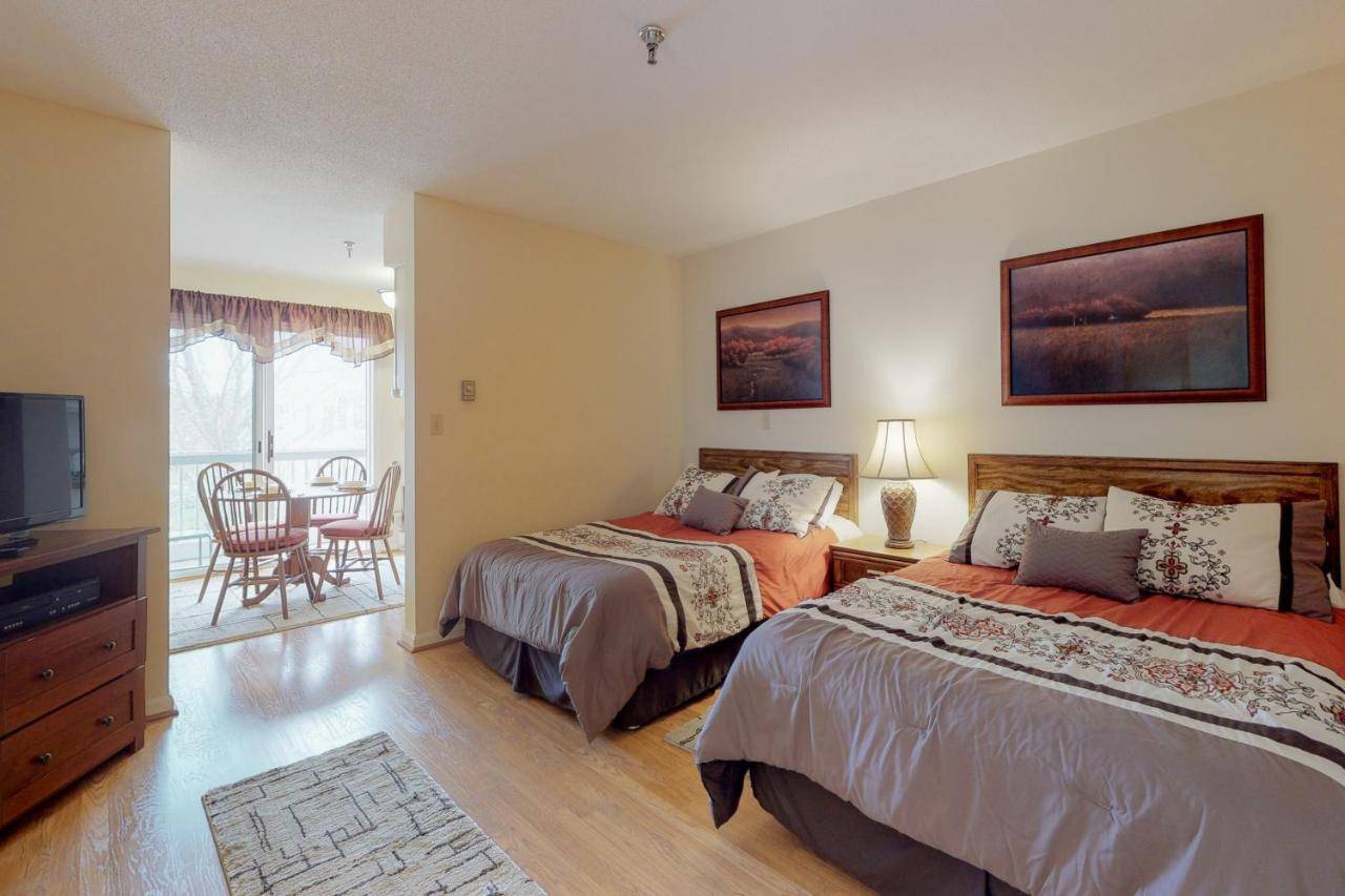 a bedroom with two beds and a television and a chair at Wellington Manor in Wells