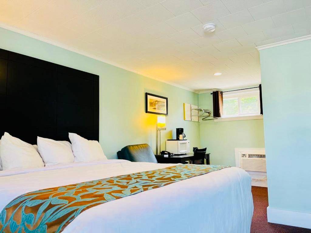 a hotel room with a large bed and a desk at Wells Moody Motel in Wells