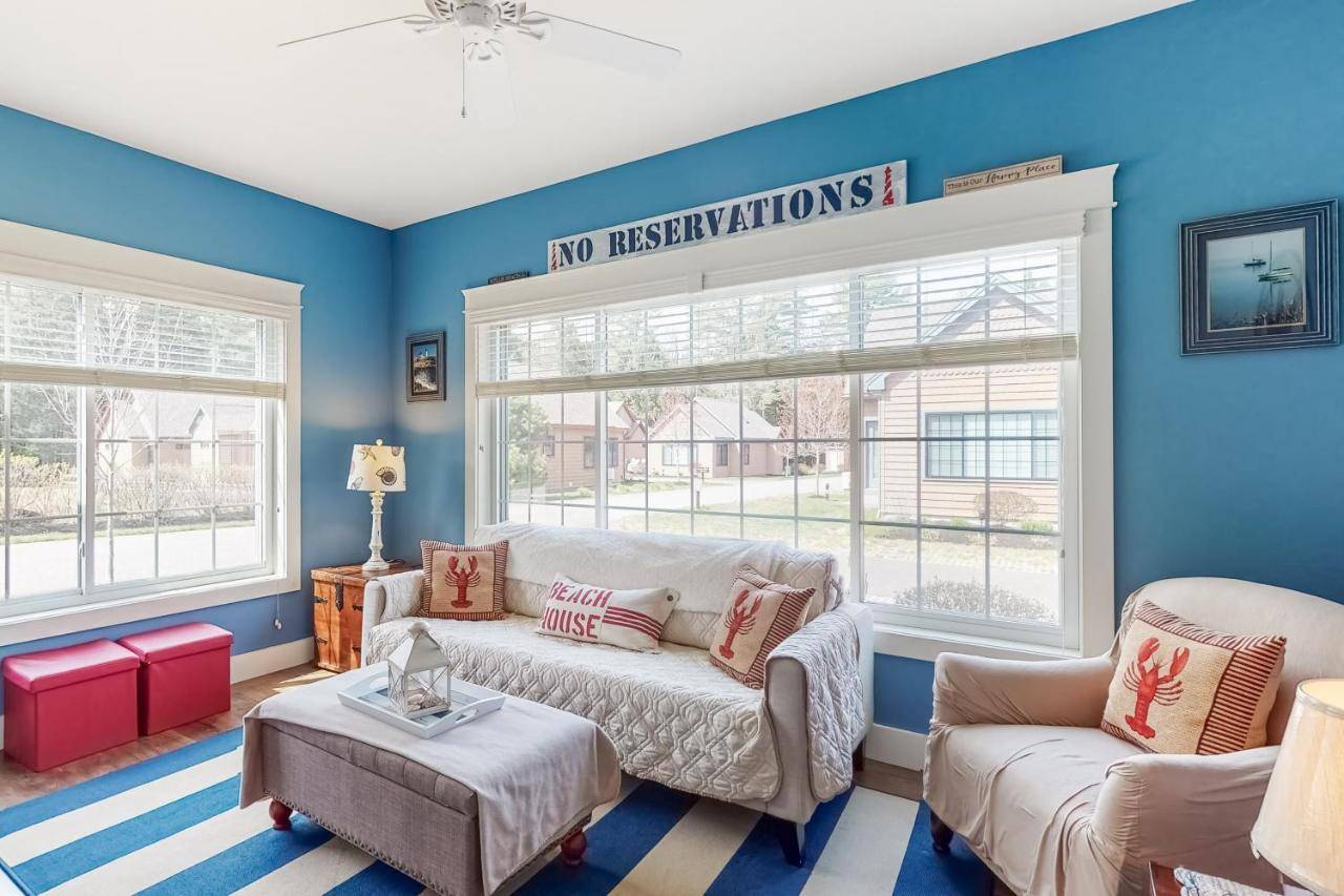 a living room with blue walls and a couch and two windows at Wells Wonder in Wells
