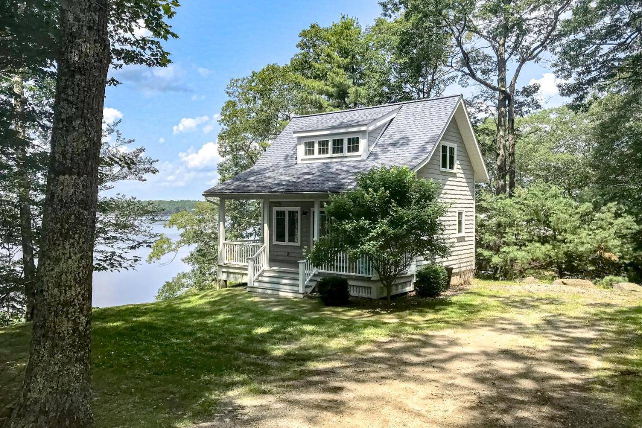 a house on the shore of a lake at Periwinkle Cottage in Westport