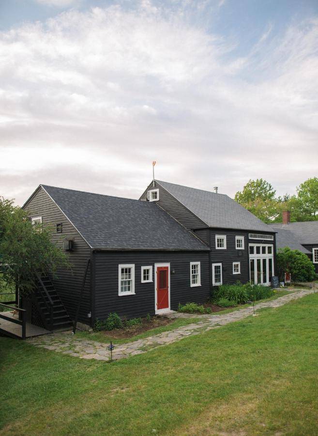 a black house with a red door at Squire Tarbox Inn in Westport