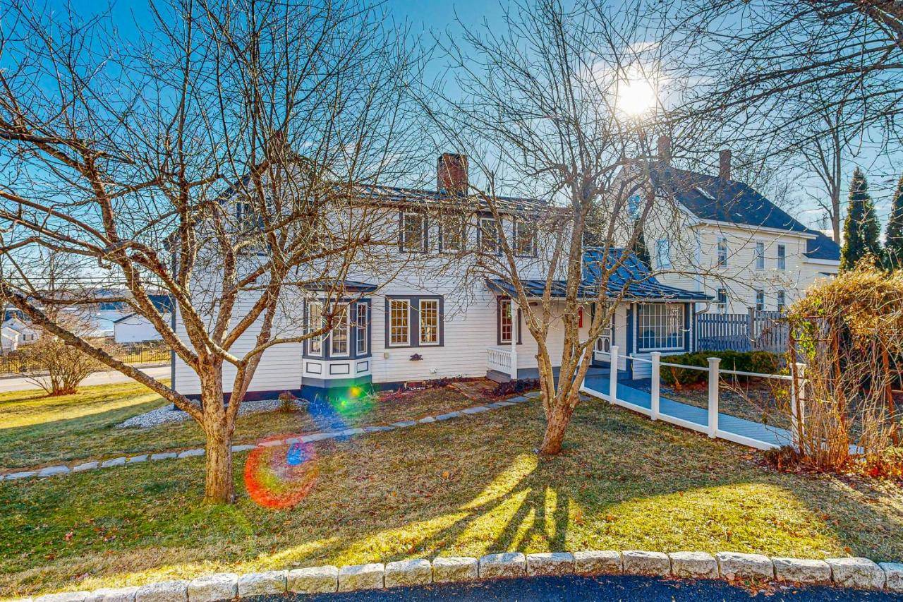 a white house with trees in front of it at Finest Kind in Wiscasset