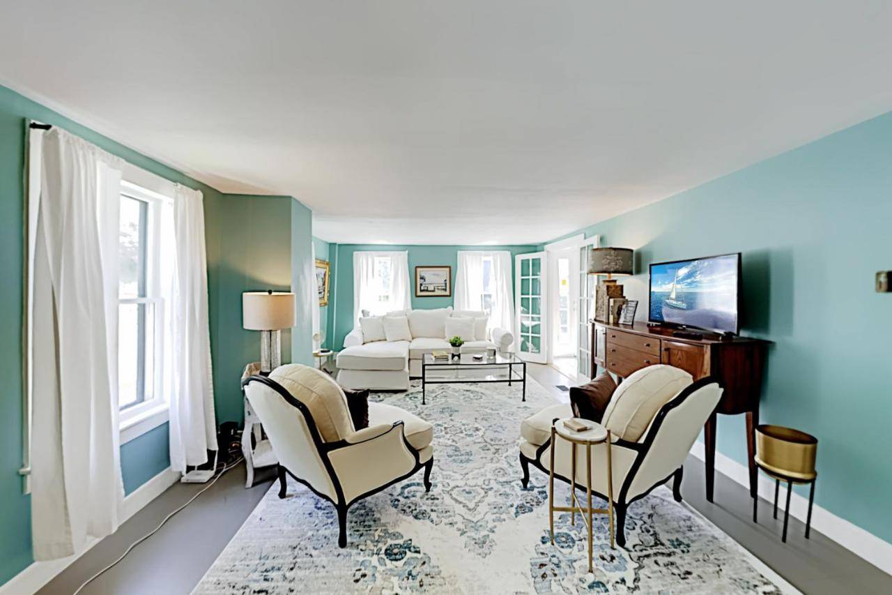 a living room with blue walls and white furniture at Wiscasset Holiday in Wiscasset