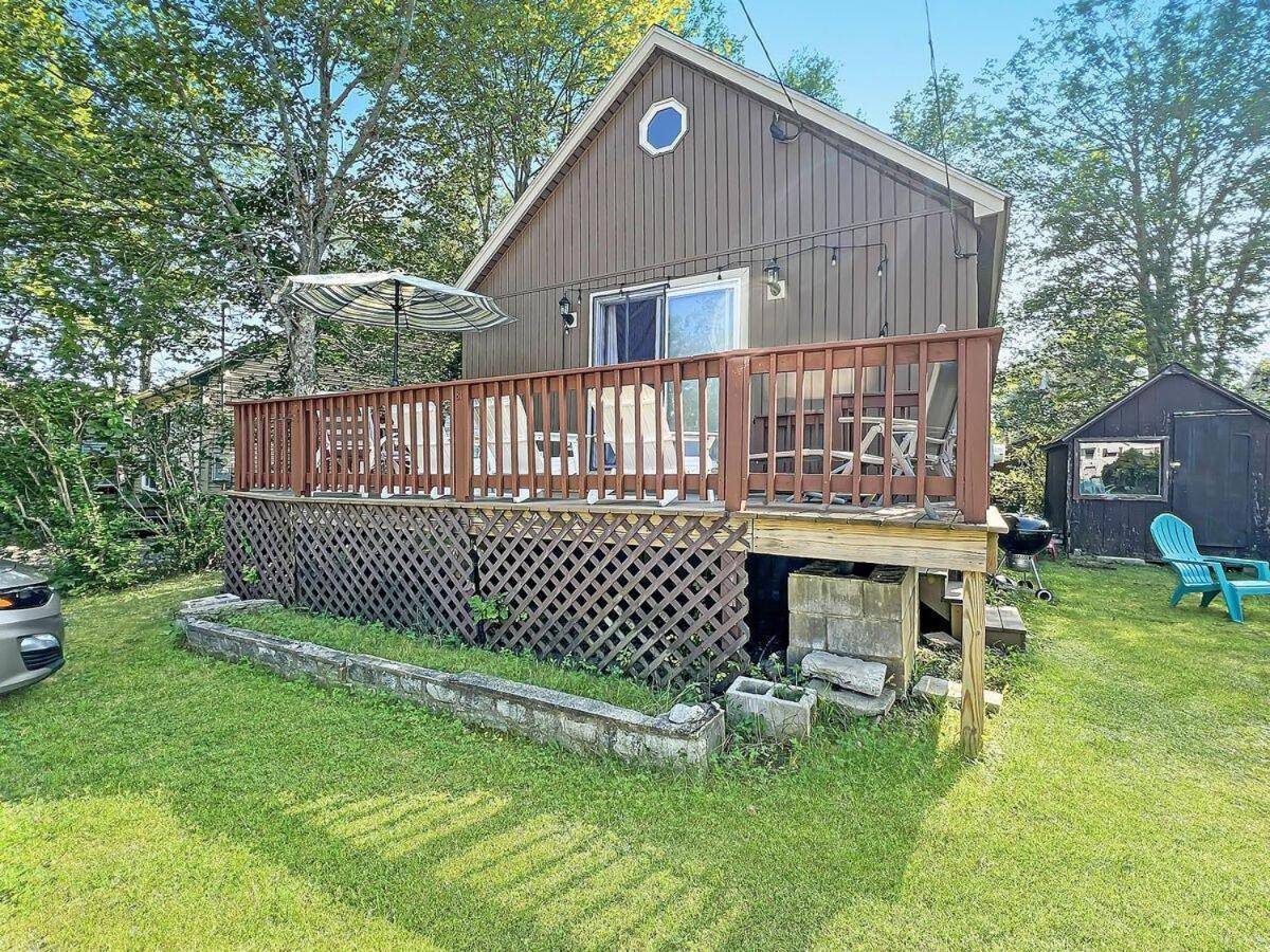 a large house with a deck on a yard at Beach Daze Cottage in York