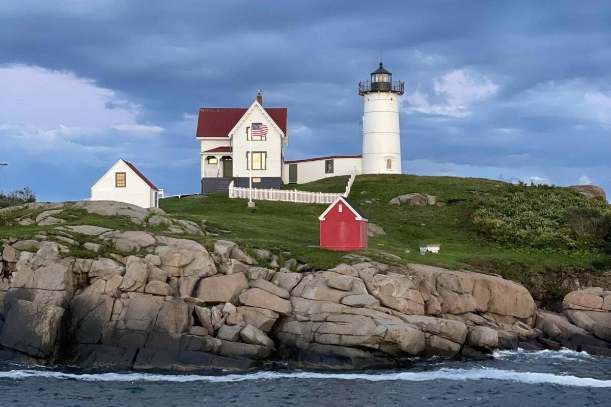 a lighthouse sitting on top of a rocky cliff at Groovy escape steps from the beach, a must sea! in York