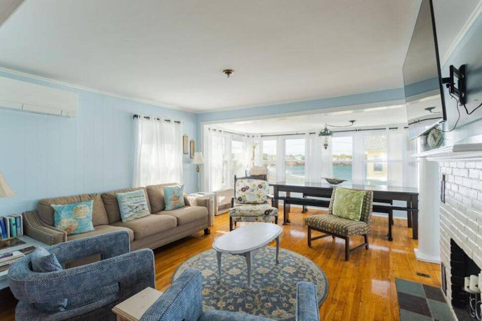 a living room with a couch and a fireplace at Oceanfront Cottage - Steps from Short Sands Beach! in York
