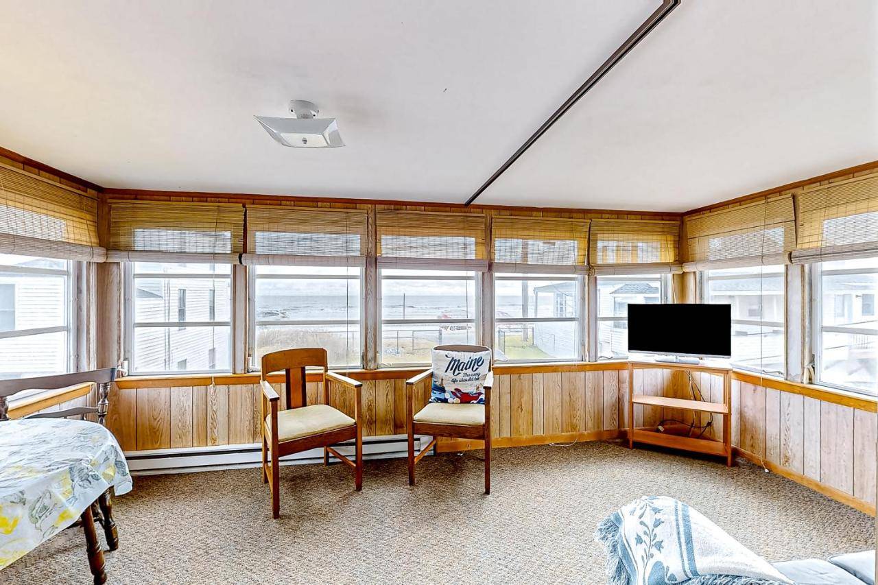 a room with a table and a tv and some windows at Pearly Shores in York