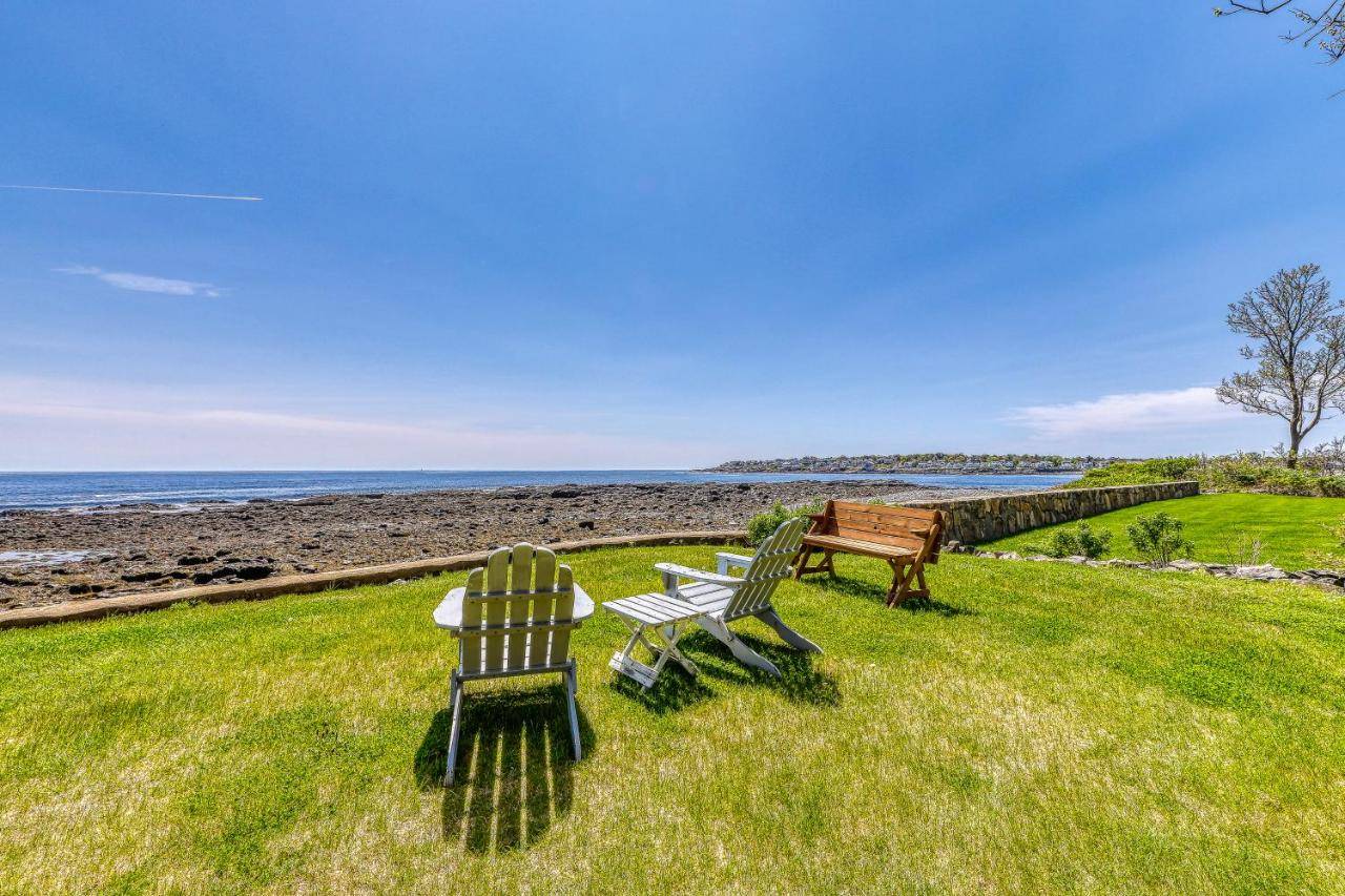 two chairs and a bench sitting on the grass near the ocean at Sea Belle in York