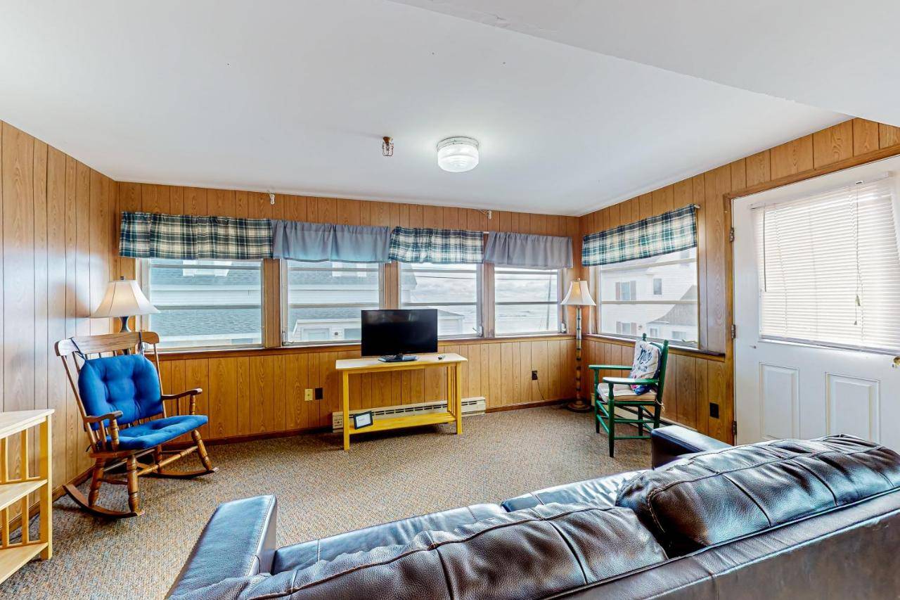 a living room with a couch and chairs and a television at Seaglass Cottage in York