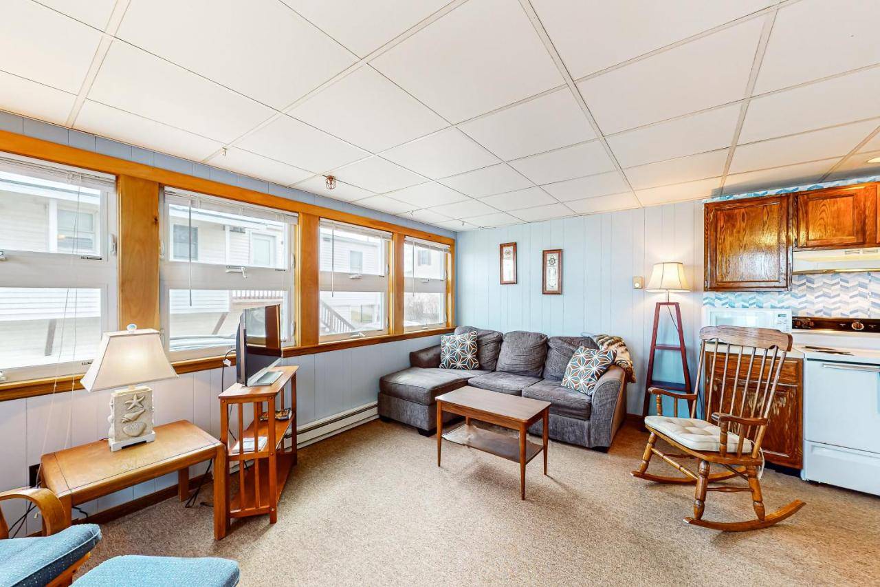 a living room with a couch and a kitchen at Shimmering Seaview in York