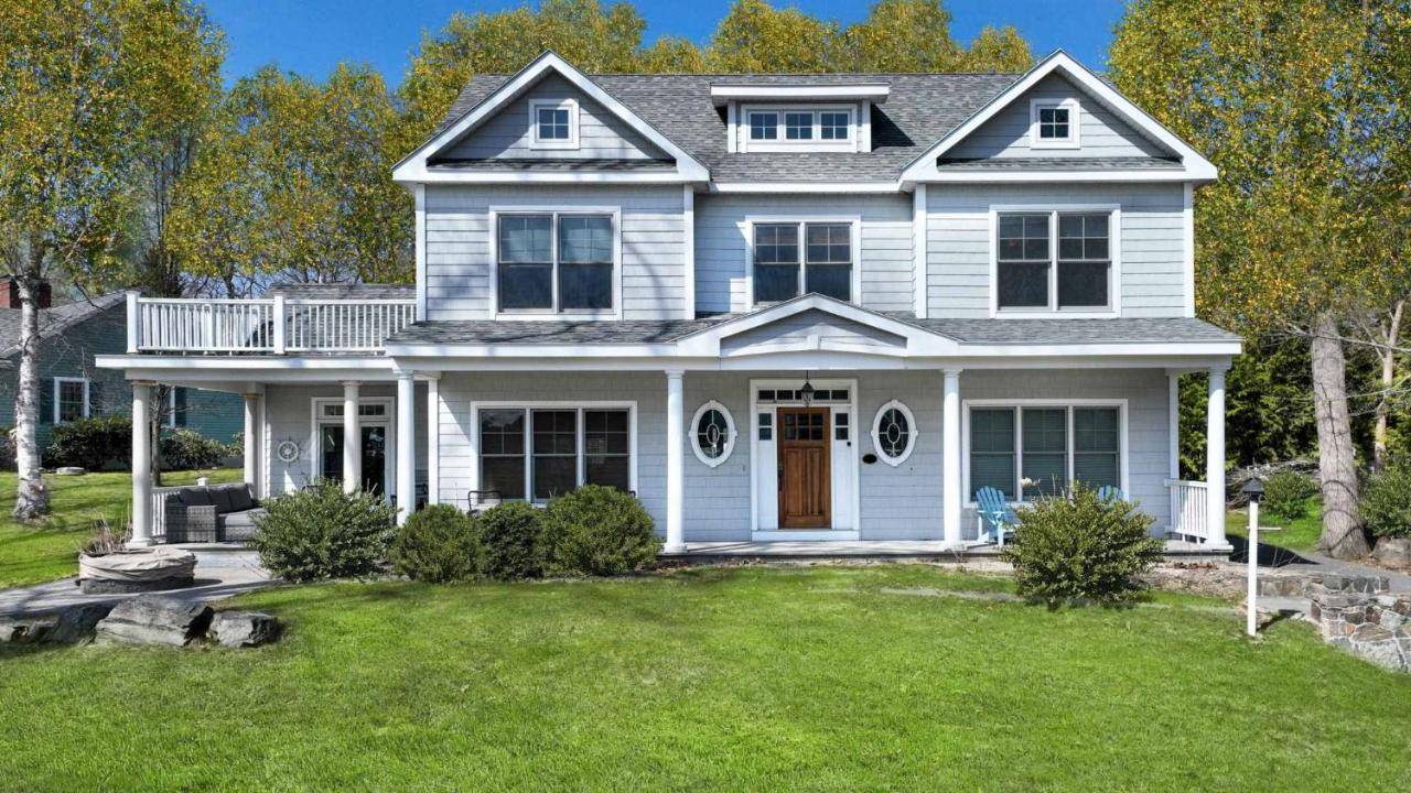 a white house with a porch and a yard at Stunning 5 BDR Walk to York Harbor Beach in York